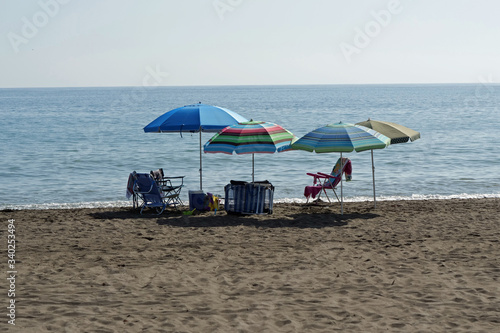 Empty chairs and sunshades on the beach are waiting for their owners to come back 