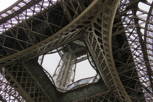 View from the ground into the construction of the famous iron landmark - the Eiffel Tower in Paris, France, Europe 