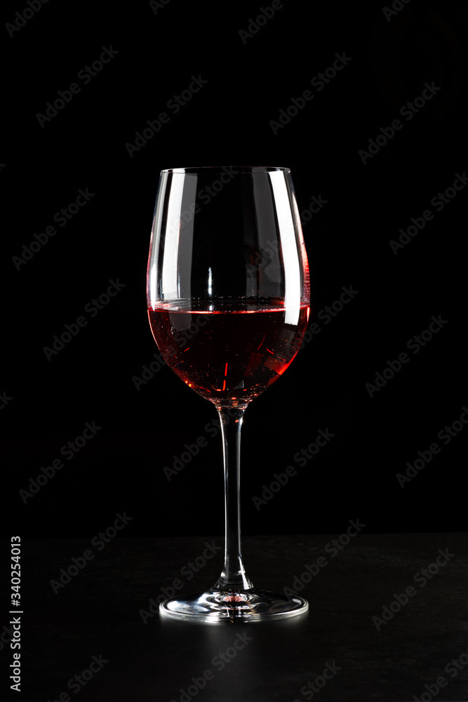 Naklejka premium A glass of red wine in dark background