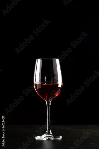 A glass of red wine in dark background