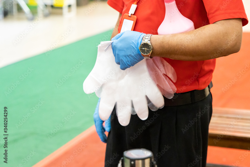 New normal lifestyle with inspectors requiring shoppers to sanitize hands and put on disposable gloves for protection before entering supermarket