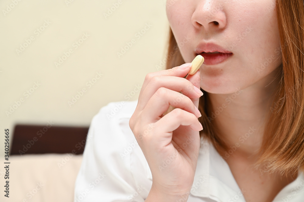 Close up Asian woman taking pill. Concept of taking daily medicine, Multivitamins and supplements and medicine to cure head ache, stomach pain sedation meds. Close up Asian woman taking pill. Concept of taking daily medicine, Multivitamins and supplements and medicine to cure head ache, stomach pain sedation meds.