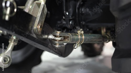 Operator on a blue tractor, excavator raises a bucket, a hitch, a mower. plow, sowing. Hydraulic pistons move forward backward. Agriculture. Working, new sowing, urban machinery. Harvesting machine