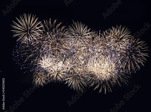 Fireworks display on dark sky background. Flashes of red and white fireworks against the night black sky. Brightly colorful fireworks
