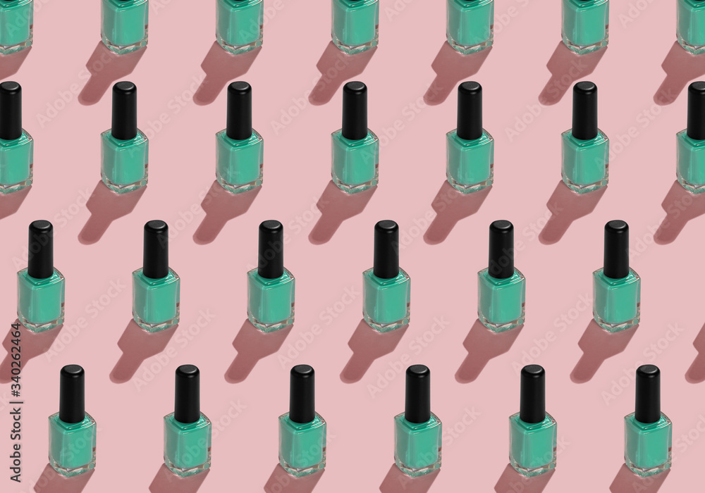 a pattern from nail enamel bottles with green enamel on pink background a pattern from nail enamel bottles with green enamel on pink background