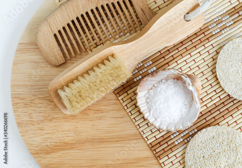 Epsom bath salts (foot soak), wooden hair brush, loofah sponge and massage body brush. Natural spa, beauty treatment, zero waste concept. Top view, copy space.