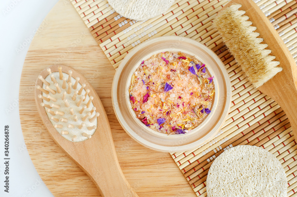 Pink floral bath salts, wooden hair brush, loofah sponge and massage body brush. Natural spa, beauty treatment, zero waste concept. Top view, copy space. Pink floral bath salts, wooden hair brush, loofah sponge and massage body brush. Natural spa, beauty treatment, zero waste concept. Top view, copy space.