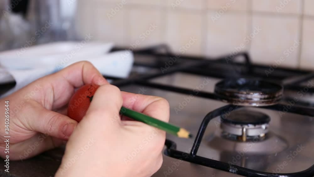 Drawing patterns with black wax with a pencil on an egg near a stove by woman hands time lapse Drawing patterns with black wax with a pencil on an egg near a stove by woman hands time lapse