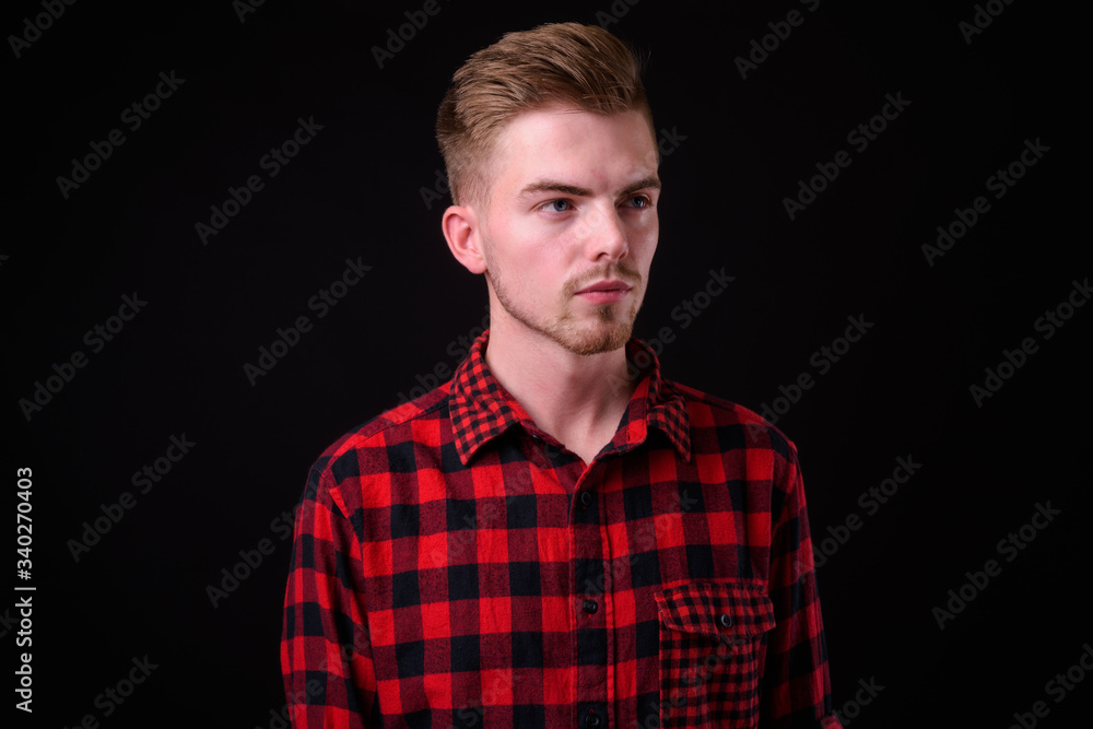 Portrait of young handsome blond bearded hipster man