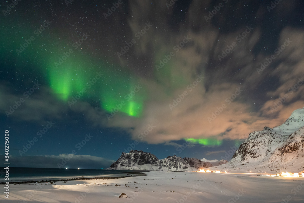 Amazing Aurora Borealis dancing over famous Uttakleiv Beach during a cold arctic night on Lofoten Islands archipelago in winter, Norway, Scandinavia