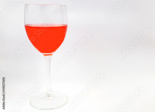 Glass goblet with red wine on a white background. Place for text