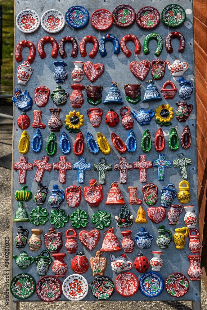 Many hand made painted wooden magnets with traditional decorations displayed for sale as souvenirs at a street market fair in Bucharest, Romania
