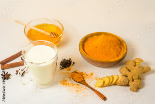 Indian traditional Golden milk with turmeric, ginger, spices, honey. healing effect of the drink. ingredients for a Golden drink on a light background. antiviral antioxidant. the view from the top