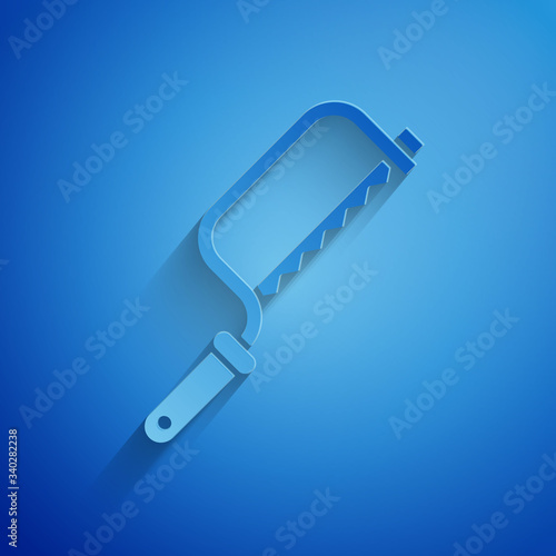 Paper cut Hacksaw icon isolated on blue background. Metal saw for wood and metal. Paper art style. Vector Illustration