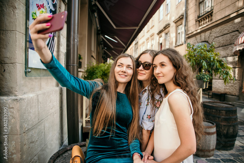 Three young women are walking in the city and having fun. Summer mood © Mila
