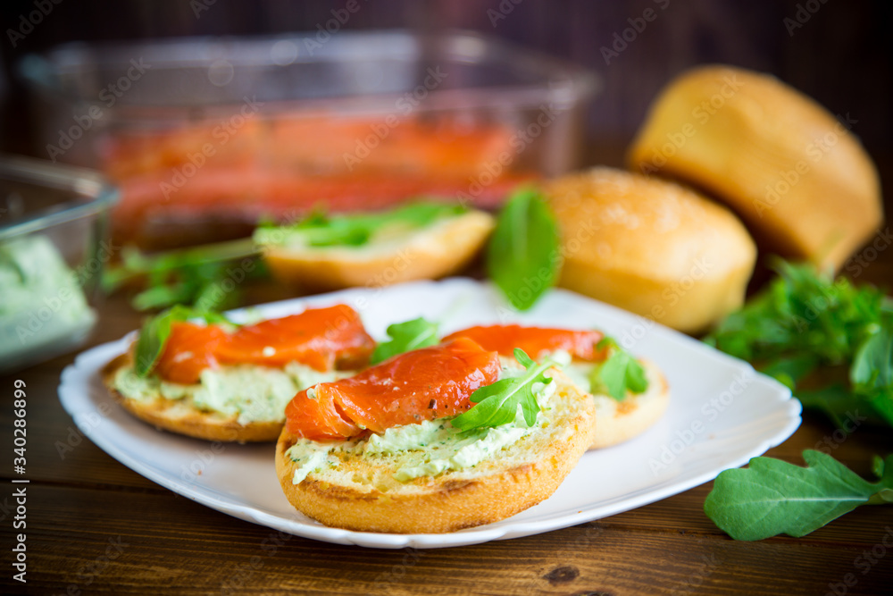 sandwich with fried bun, cheese spread and red fish in a plate
