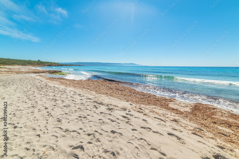 Sun shining over Le Bombarde beach in Sardinia