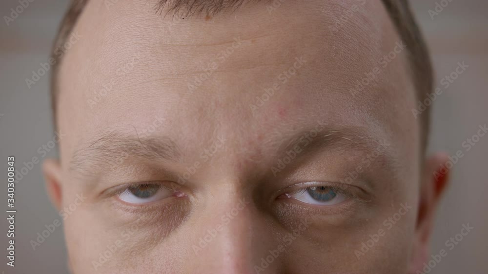 Wide open gray eyes of a young man. Looking directly at the camera, close-up Wide open gray eyes of a young man. Looking directly at the camera, close-up