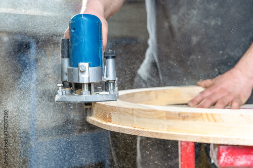 Milling of the Round wooden window using handheld electric cutters in joinery