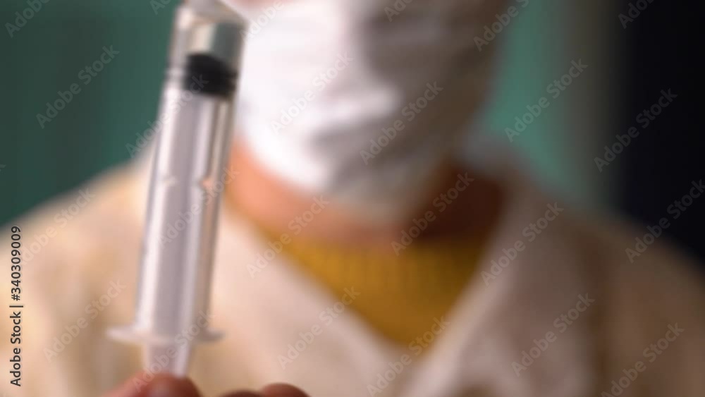 A doctor or scientist in laboratory holding a syringe with liquid vaccines for children or older adults, or cure animal diseases. Concept:diseases,medical care,science, anesthesia,euthanasia,diabetes. A doctor or scientist in laboratory holding a syringe with liquid vaccines for children or older adults, or cure animal diseases. Concept:diseases,medical care,science, anesthesia,euthanasia,diabetes.