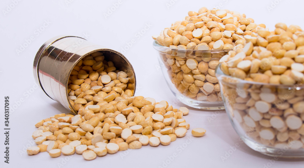 Group of a healthy roasted gram in a bowl with brass measuring jar on a white background Group of a healthy roasted gram in a bowl with brass measuring jar on a white background