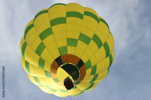 Yellow and Green Hot Air Balloon In Flight Close Up From Below