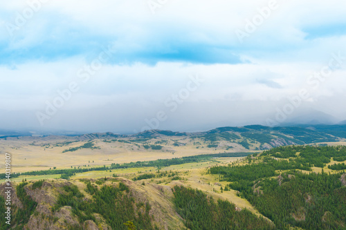 forest mountain valley under blue sky with clouds, tourist route for trekking, place of recreation and relaxation