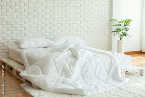 Bilde på lerret Messed bed with white pillow and blanket with natural light in bedroom in the mo