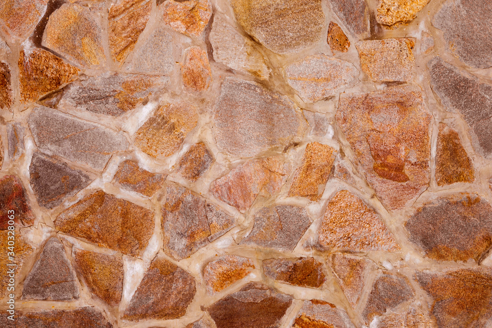 Texture of a part of a wall made of masonry of stone boulders. Part of the structure, external part of the structure.