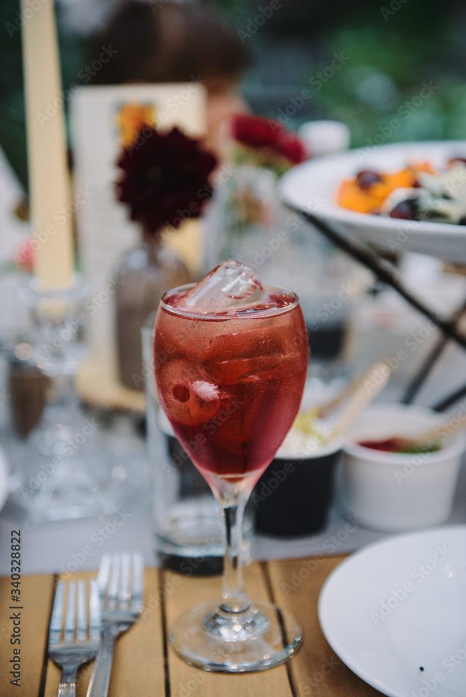 Pink cocktail with ice on a table at a party. Pink cocktail with ice on a table at a party.
