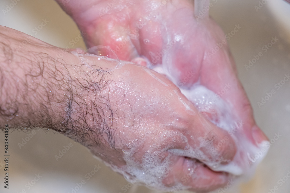 Personal hygiene and prevention of the coronavirus pandemic wash men's hands with soap and water. Personal hygiene and prevention of the coronavirus pandemic wash men's hands with soap and water.