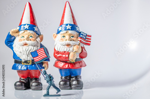 Bild auf Leinwand Patriotic gnomes salute a passing flag on Independence Day
