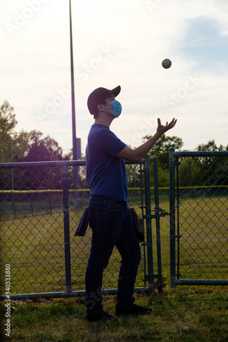 Images of young man wearing a COVID-19 mask at a closed baseball field.