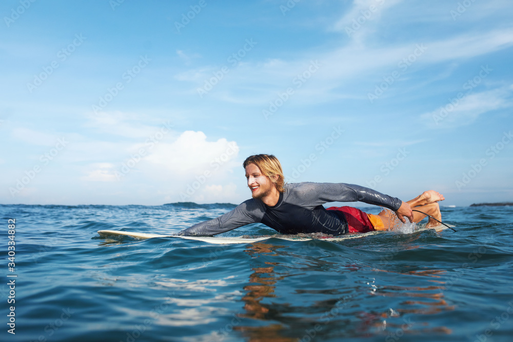 Man In Water. Surfer In Wetsuit On Surfboard.