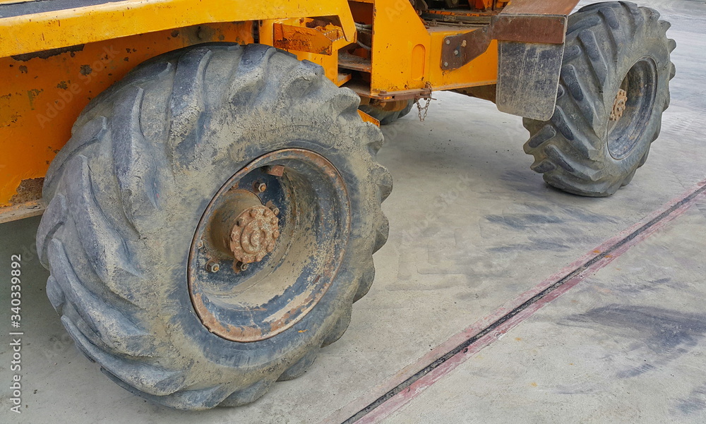 Old construction dump truck wheels and tires on the concrete floor Old construction dump truck wheels and tires on the concrete floor