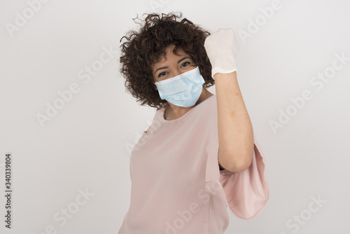 Overjoyed happy excited female wearing medical mask glad to receive good news, gestures actively from happiness, clenching fist and making winning gesture. Reaction concept. © Jihan