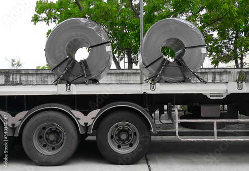 Rolled steel coil on the truck, fixed by chain. Transportation material to the steel service center and the customers