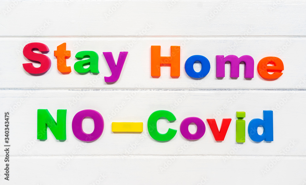 Stay home no Covid Sign & Symbol, plastic letter on white wood background Stay home no Covid Sign & Symbol, plastic letter on white wood background