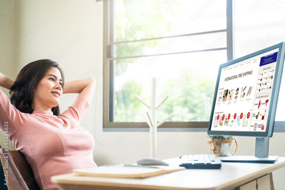 Asian young business woman has relax time by shopping after finish working on computer. During Coronavirus crisis Covid19 outbreak Social distancing girl work from home for prevent contract a disease. Asian young business woman has relax time by shopping after finish working on computer. During Coronavirus crisis Covid19 outbreak Social distancing girl work from home for prevent contract a disease.