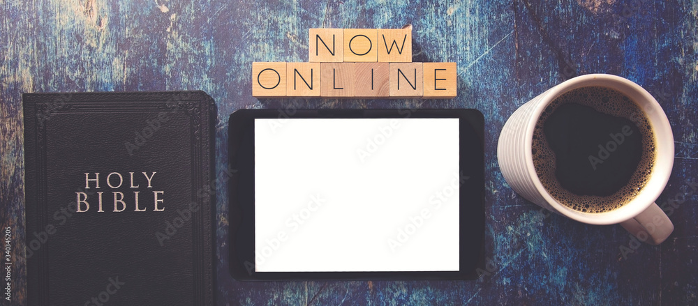 Now Online Written in Block Letters on a Wooden Table with Bible and Tablet Now Online Written in Block Letters on a Wooden Table with Bible and Tablet