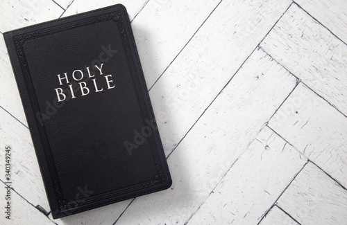 Tablou canvas A Black Holy BIble on a White Wooden Table