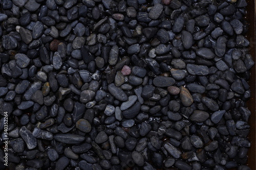Black Dark Pebbles For Background or Texture Moody Wet Stone surface gloomy abstract muted colors