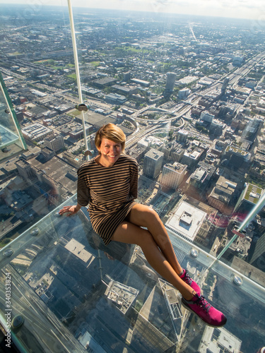 Tourists posing on a glass floor photo