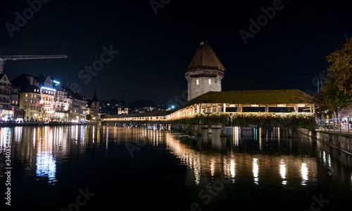 Illuminated Lucerne and Chapel Bridge reflect on the river