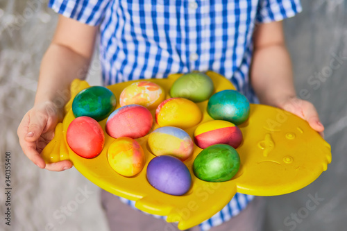 Easter eggs on a stand in the hands, the holiday of bright Easter