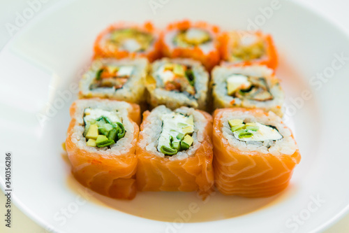 set of sushi and rolls on white plate on white background. delicious japanese traditional food. Fish menu. assorted seafood