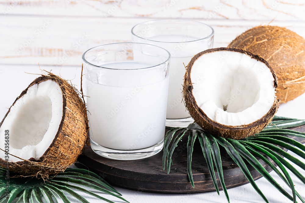 Fresh healthy sugar free coconut water in a glass on white wooden background. Organic non dairy drink on the table. Fresh healthy sugar free coconut water in a glass on white wooden background. Organic non dairy drink on the table.