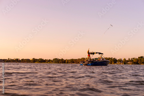 A girl about to wakeboard while tossing a rope in the water from her boat