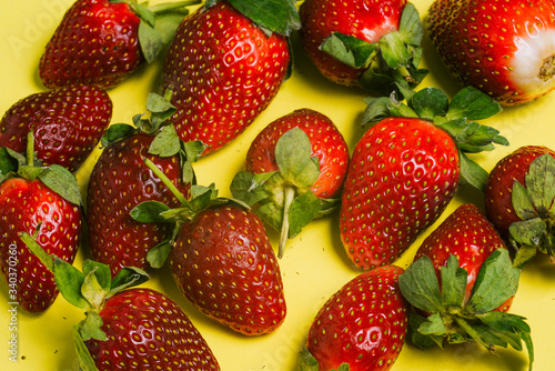 Strawberries on a yellow background. Fresh sweet fruit close-up.