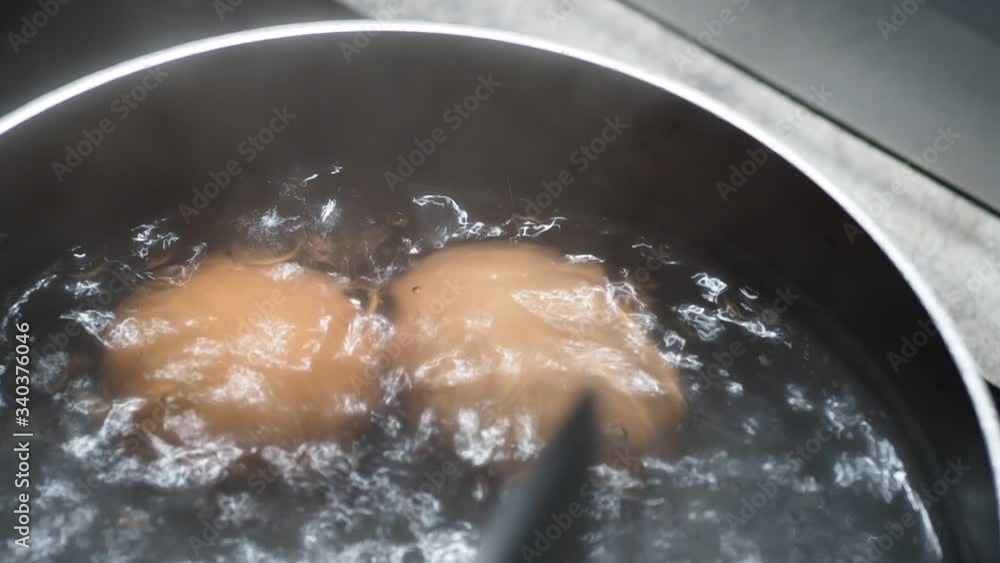 Two eggs in boiling hot water. Then one is spooned out for serving. Concept for breakfast, cooking eggs and simple quick meals. Two eggs in boiling hot water. Then one is spooned out for serving. Concept for breakfast, cooking eggs and simple quick meals.